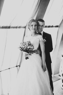 Güzel, genç bir çift ellerinde çiçeklerle poz veriyorlar.