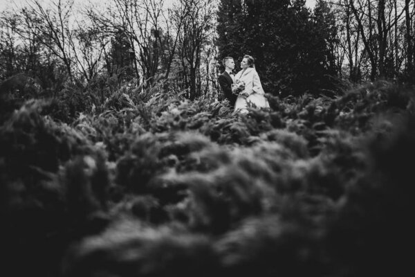 Wedding couple on the nature is hugging each other. Beautiful model girl in white dress. Man in suit.