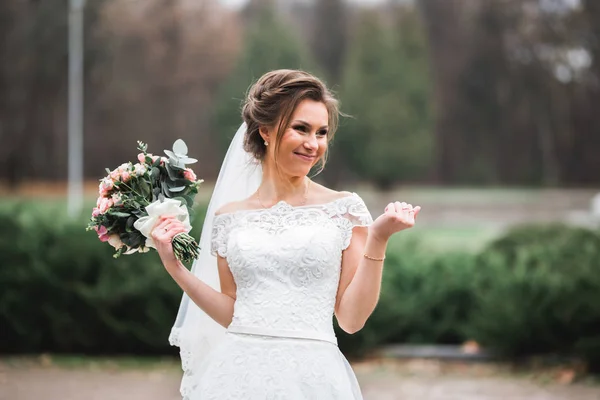 Retrato de novia impresionante con el pelo largo posando con gran ramo — Foto de Stock