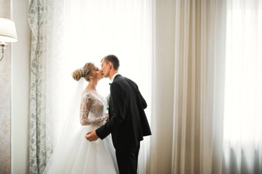 Güzel gelin ve damat düğün günlerinde kucaklaşıp öpüşürler.