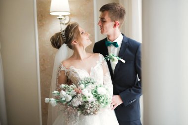 Güzel, genç bir çift ellerinde çiçeklerle poz veriyorlar.