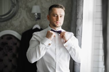 Güzel adam, damat poz veriyor ve düğüne hazırlanıyor.