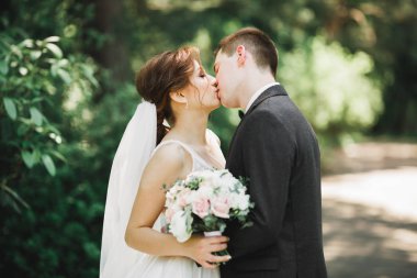 Güzel gelin ve damat düğün günlerinde kucaklaşıp öpüşürler.