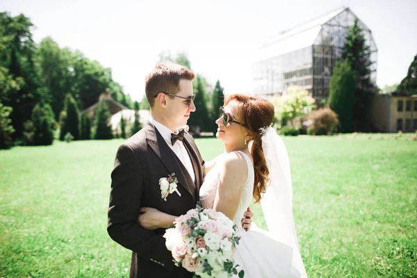 Happy wedding couple bride and groom smiling in sunglasses on the nature — 图库照片