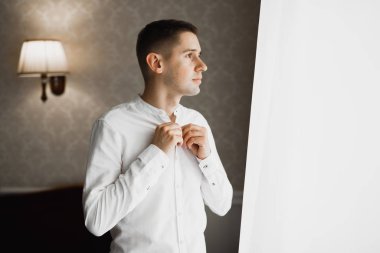 Güzel adam, damat poz veriyor ve düğüne hazırlanıyor.