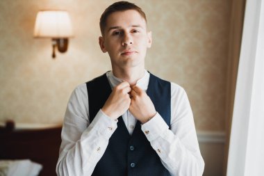 Güzel adam, damat poz veriyor ve düğüne hazırlanıyor.