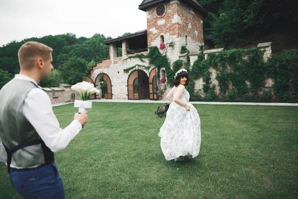 Romantický svatební okamžik, nevěsta utíká od ženicha v parku — Stock fotografie