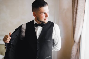 Güzel adam, damat poz veriyor ve düğüne hazırlanıyor.