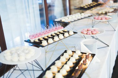 Çeşitli lezzetli tatlılar, yemek fikirleri ve kutlamalarla dolu bir büfe.