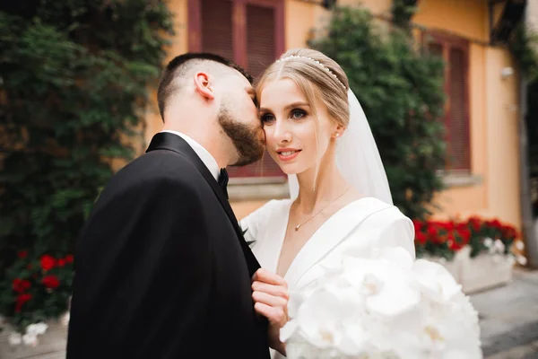 Casal feliz encantador do casamento, noiva com vestido branco longo posando na cidade bonita — Fotografia de Stock