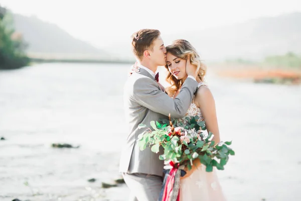 Boda pareja, novio y novia abrazos, al aire libre cerca del río —  Fotos de Stock