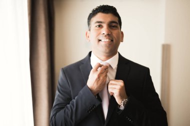 Güzel adam, damat poz veriyor ve düğüne hazırlanıyor.