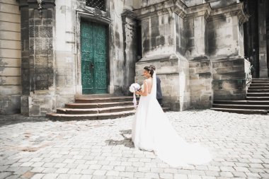 Güzel, mutlu bir düğün çifti, güzel şehirde uzun beyaz elbiseli bir gelin.