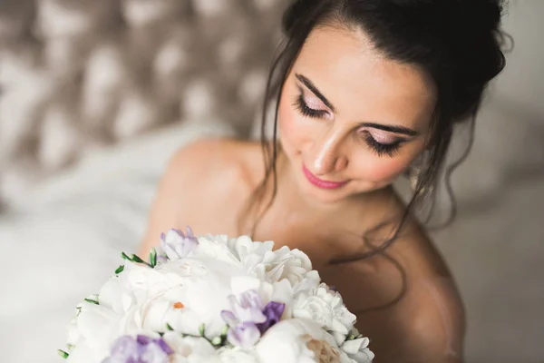 Linda noiva em roupão posando e se preparando para o rosto cerimônia de casamento em uma sala — Fotografia de Stock