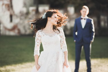 Güzel, mutlu bir düğün çifti, güzel şehirde uzun beyaz elbiseli bir gelin.