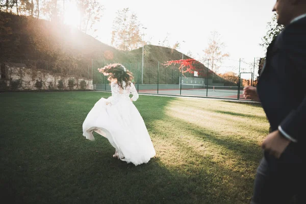 Preciosa pareja feliz boda, novia con vestido blanco largo posando en la hermosa ciudad —  Fotos de Stock