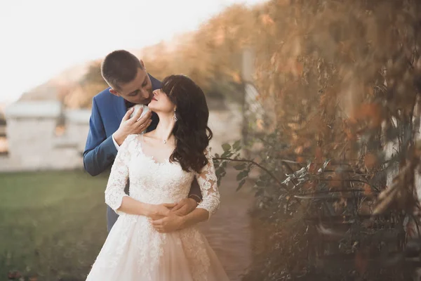 Casal feliz encantador do casamento, noiva com vestido branco longo posando na cidade bonita — Fotografia de Stock