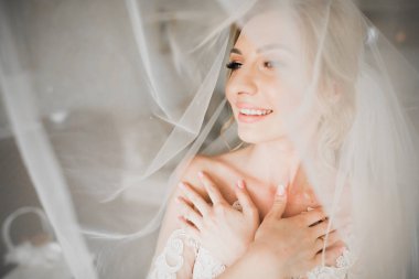 Beyaz elbiseli lüks gelin düğün törenine hazırlanırken poz veriyor.