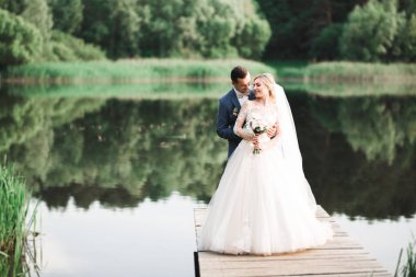 Romantik düğün anı, yeni evli çiftin gülümseyen portresi, gelin ve damadın kucaklaşması