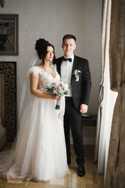 Güzel, genç bir çift ellerinde çiçeklerle poz veriyorlar.