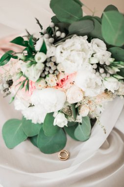 Çiçek buketinin arka planında alyanslar olan güzel renkli bir resim.