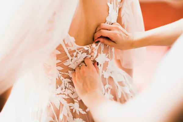 Mains de demoiselles d'honneur sur la robe de mariée. Mariage heureux et mariée au concept du jour du mariage — Photo
