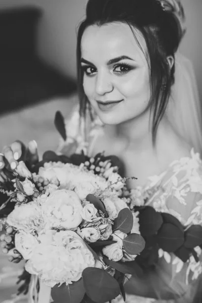 Preciosa novia en bata posando y preparándose para la ceremonia de boda cara en una habitación —  Fotos de Stock