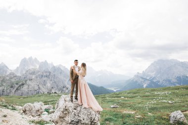 Harika bir gelin damada poz veriyor ve harika manzaralı dağlarda eğleniyor. Mesajlaşacak yer, düğün çifti.