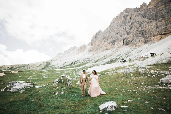 Çift, gelin ve damat dağlarda el ele tutuşuyorlar. — Stok fotoğraf