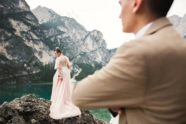 Hermosa pareja moderna cerca de un lago en las montañas hacer fotos de boda —  Fotos de Stock