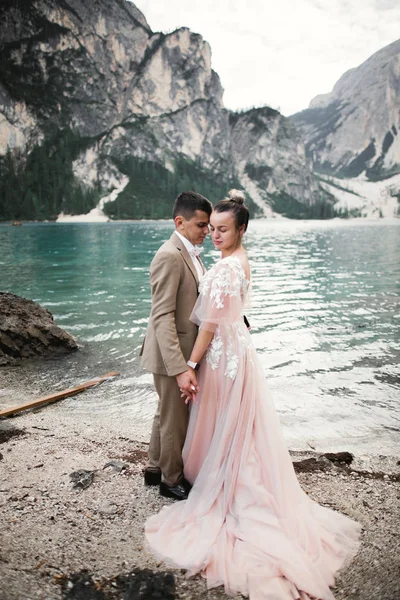 Jong stel bij het meer van Karersee, Italië. Handjes vasthouden aan de steen bij het meer — Stockfoto