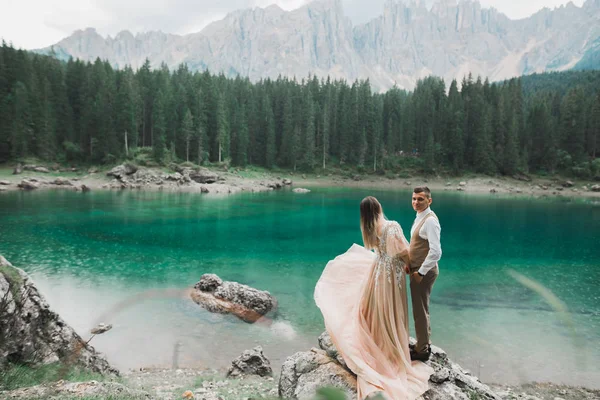 Hermosa pareja moderna cerca de un lago en las montañas hacer fotos de boda —  Fotos de Stock