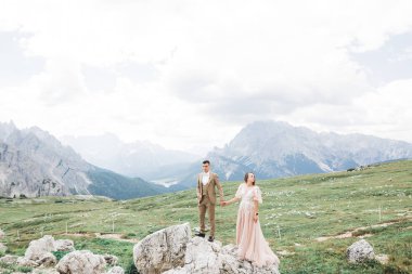 Harika bir gelin damada poz veriyor ve harika manzaralı dağlarda eğleniyor. Mesajlaşacak yer, düğün çifti.