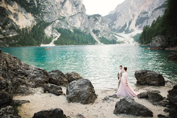 Coppia giovane vicino al lago Karersee, Italia. Tenendo per mano la pietra al lago — Foto Stock