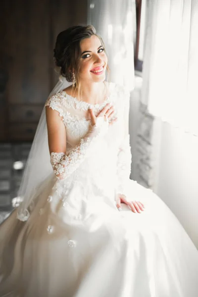 Linda noiva em roupão posando e se preparando para o rosto cerimônia de casamento em uma sala — Fotografia de Stock