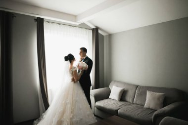 Göz kamaştırıcı mutlu çift birbirine yakın duruyor ve gözlerinin içine bakıyor.