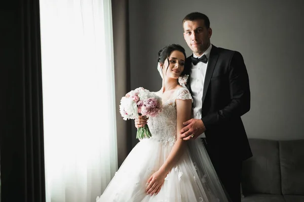 Hochzeitspaar in der Natur umarmt sich. Schöne Modell Mädchen in weißem Kleid. Mann im Anzug — Stockfoto