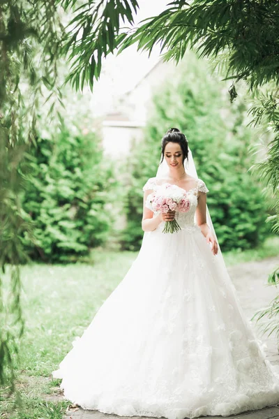 Retrato de novia impresionante con el pelo largo posando con gran ramo — Foto de Stock