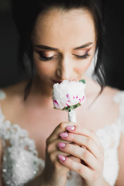 Schöne Luxusbraut im eleganten weißen Kleid hält Blumenstrauß in den Händen — Stockfoto