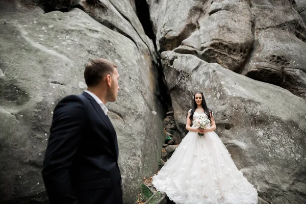 Belle mariée magnifique posant pour se toiletter et s'amuser près des montagnes avec une vue imprenable, espace pour le texte, couple de mariage — Photo