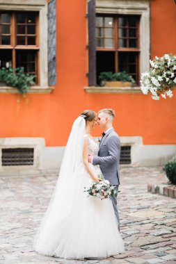 Doğadaki düğün çifti birbirine sarılıyor. Beyaz elbiseli güzel bir kız. Takım elbiseli adam