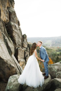 Güzel gelin ve damat evlendikleri gün kucaklaşıp öpüşüyorlar.