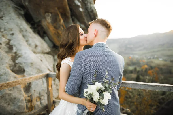 Bela noiva e noivo abraçando e beijando em seu dia de casamento ao ar livre — Fotografia de Stock