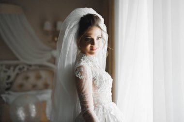 Beyaz elbiseli lüks gelin düğün törenine hazırlanırken poz veriyor.