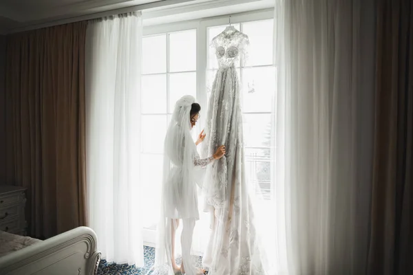 Novia de lujo en vestido blanco posando mientras se prepara para la ceremonia de boda — Foto de Stock