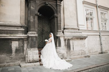 Gelin çiçekli büyük ve güzel bir düğün buketi tutuyor.