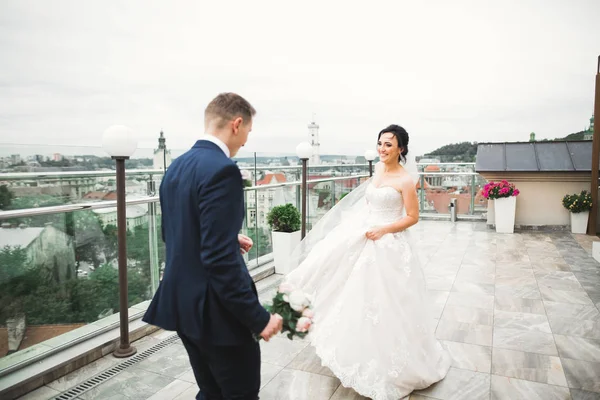 Casal elegante de recém-casados felizes. Noiva correndo do noivo no parque em seu dia de casamento com buquê — Fotografia de Stock