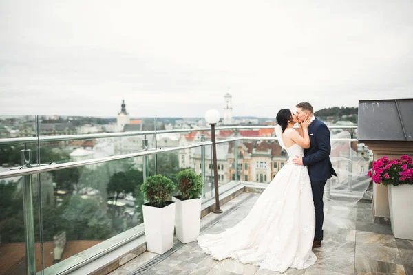 Bela noiva e noivo abraçando e beijando em seu dia de casamento ao ar livre — Fotografia de Stock