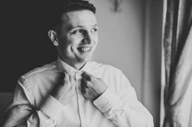 Güzel adam, damat poz veriyor ve düğüne hazırlanıyor.