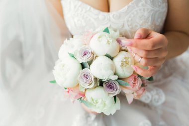 Çekici gelinin portresi, uzun saçlı, büyük buketli poz veren.